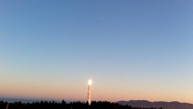 夕暮れの空を背景に、Minotaur IVロケットが軍事衛星を搭載して打ち上げられる様子。