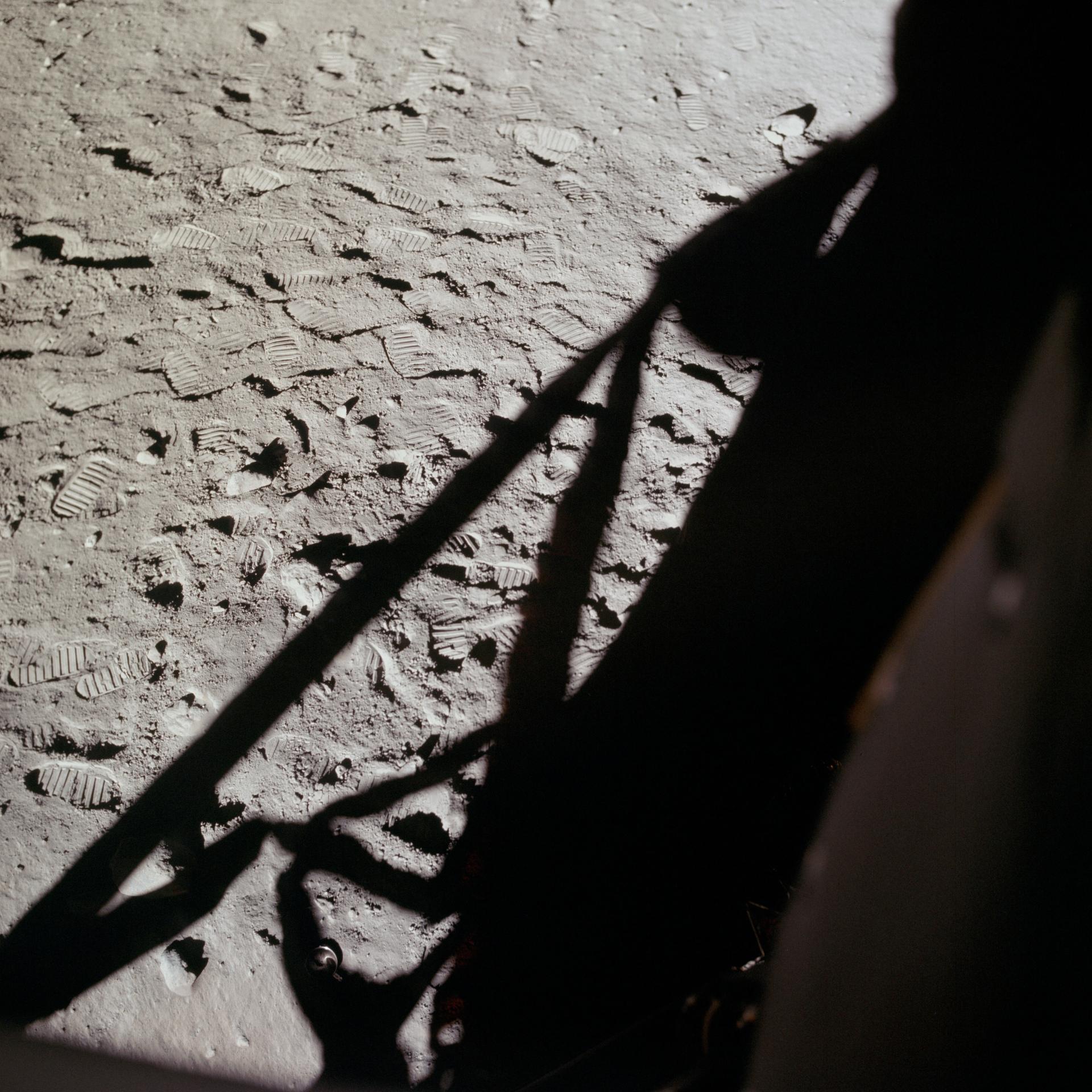 月面に残された宇宙飛行士の足跡と着陸船の影。