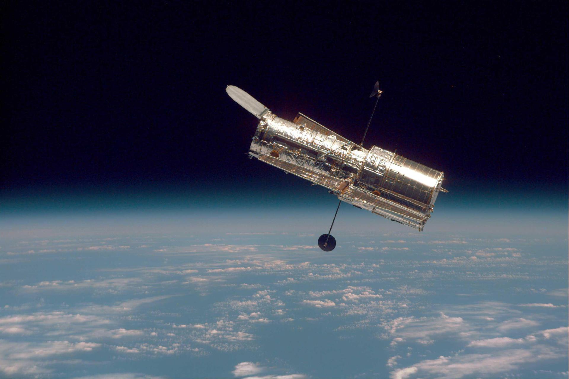 ハッブル宇宙望遠鏡が地球上空で太陽光を受けながら軌道を周回する様子